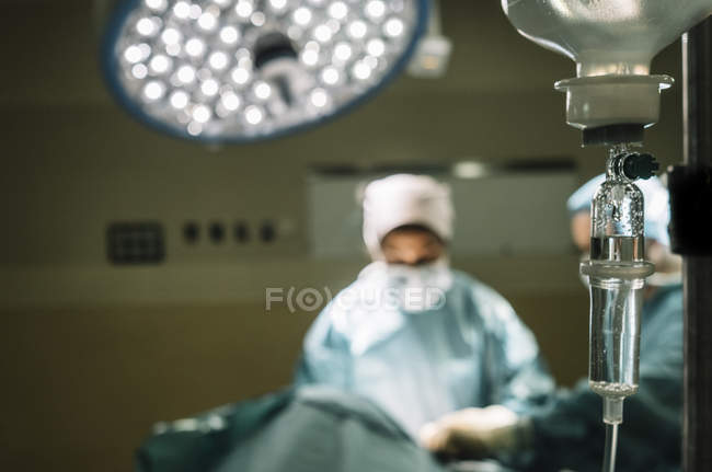 Drop bottle over blurred operation — Stock Photo