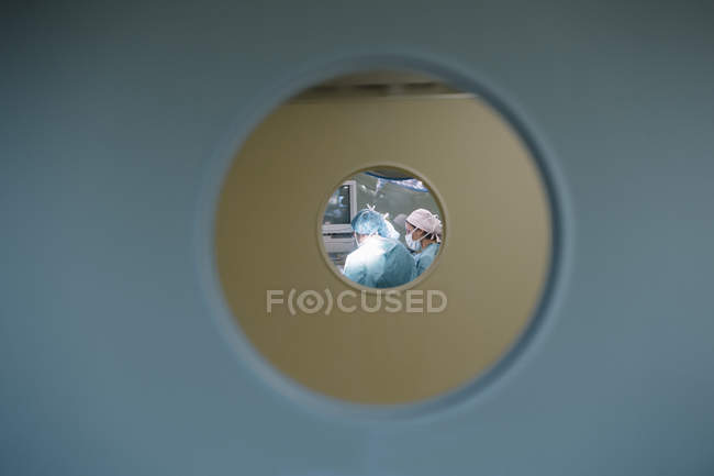 Vista dei medici durante l'intervento chirurgico attraverso la finestra della porta — Foto stock