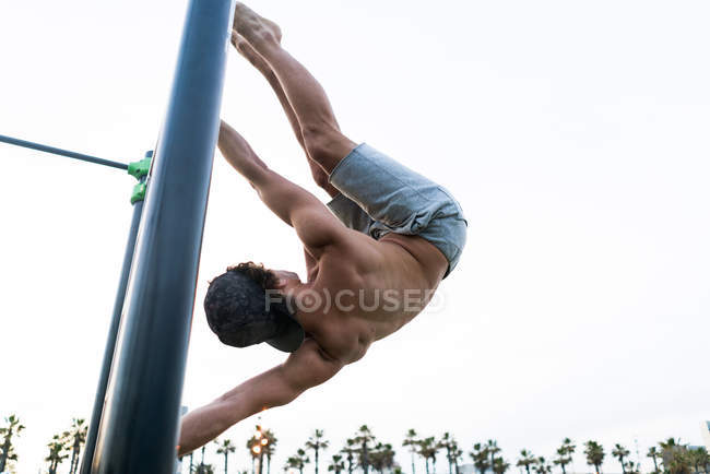Hombre anónimo haciendo ejercicio en el campo de deportes - foto de stock