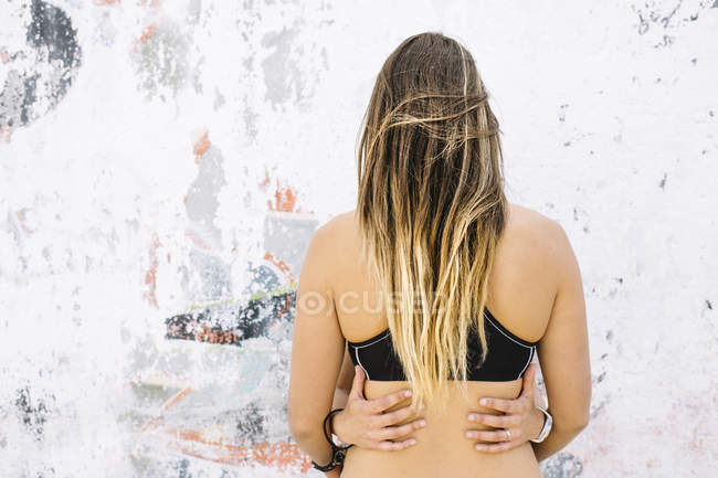 Casal lésbico abraço perto da parede — Fotografia de Stock
