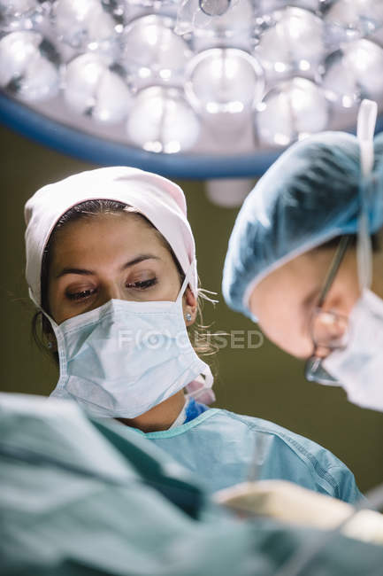 Médicos en la operación de procesamiento de máscara - foto de stock
