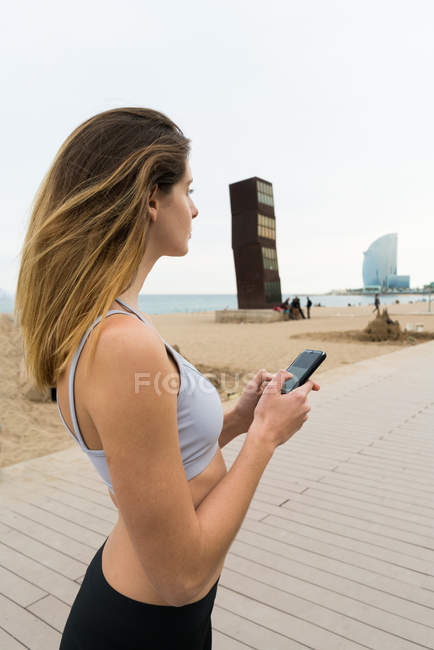 Sportive woman with smartphone — Stock Photo
