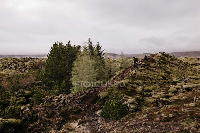Uomo anonimo sulle colline rocciose — Foto stock