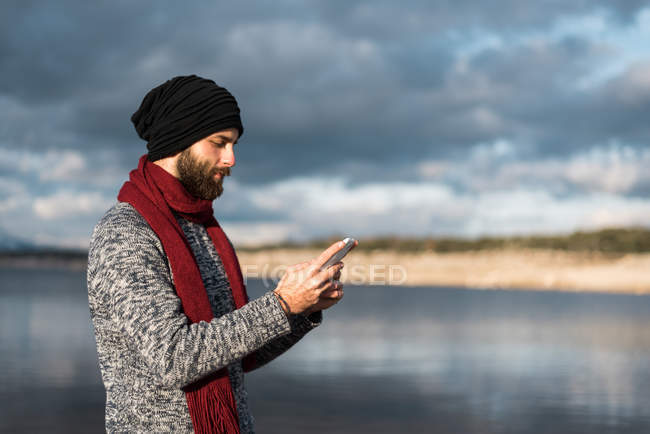 Man browsing phone in nature — Stock Photo