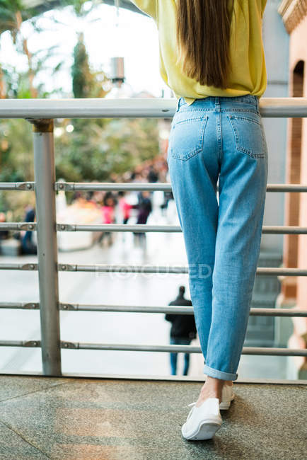 Donna in jeans al corrimano — Foto stock