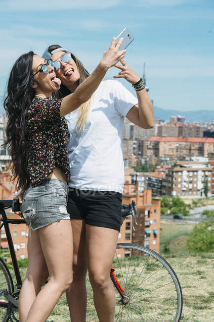 Un beau jeune couple lesbien avec smartphone — Photo de stock