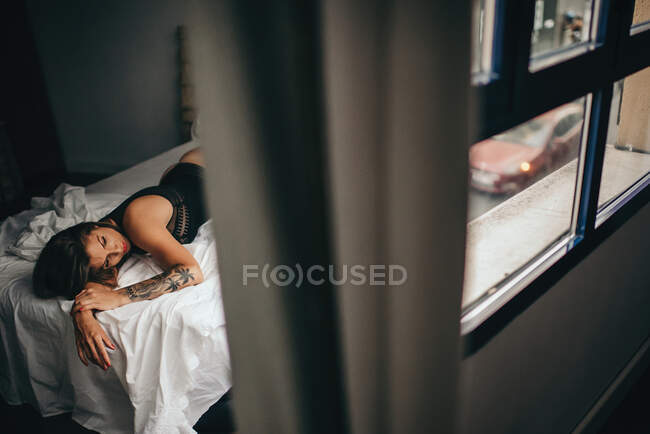 Горизонтальний знімок в приміщенні привабливої молодої жінки, що лежить і спить у ліжку — стокове фото
