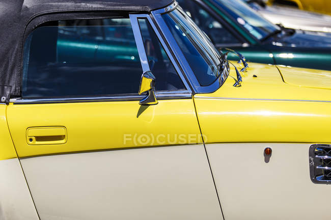 Обрезанное изображение ретро-желтого автомобиля в солнечный день — стоковое фото