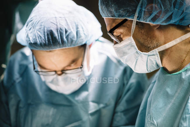 Surgeons in masks looking down — Stock Photo