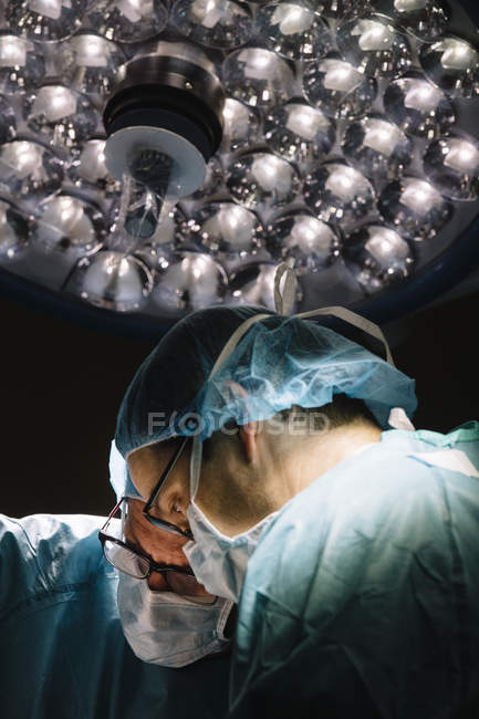 Хірурги, що стоять під лампою — стокове фото