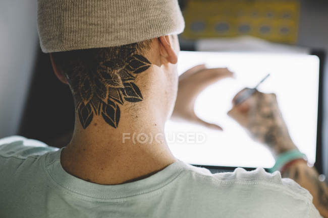 Over shoulder view tattoo master drawing sketch — Stock Photo