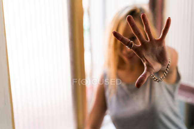Жінка показує руку на камеру — стокове фото