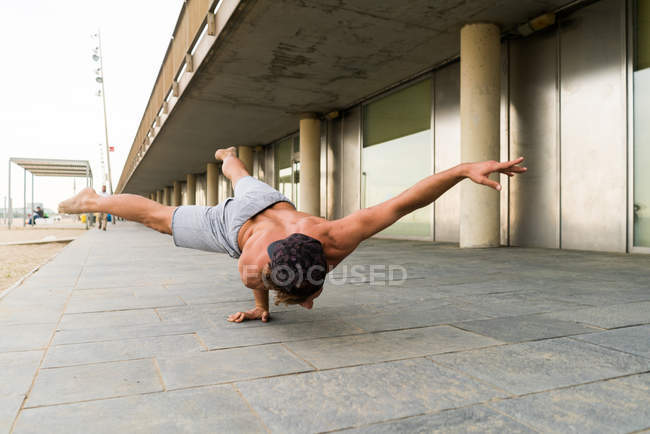 Mann macht einarmigen Handstand — Stockfoto