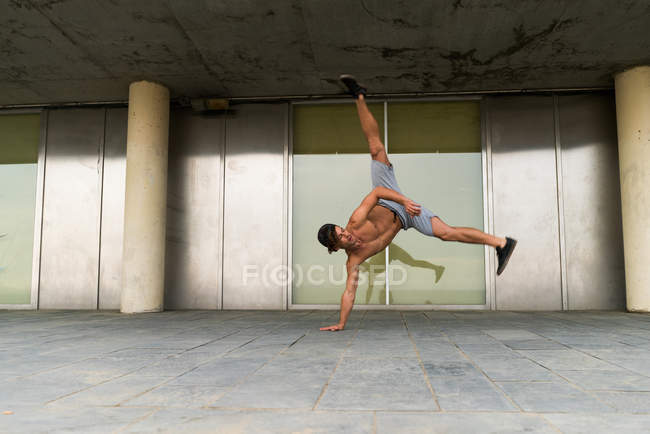 Shirtless man in handstand on street — Stock Photo