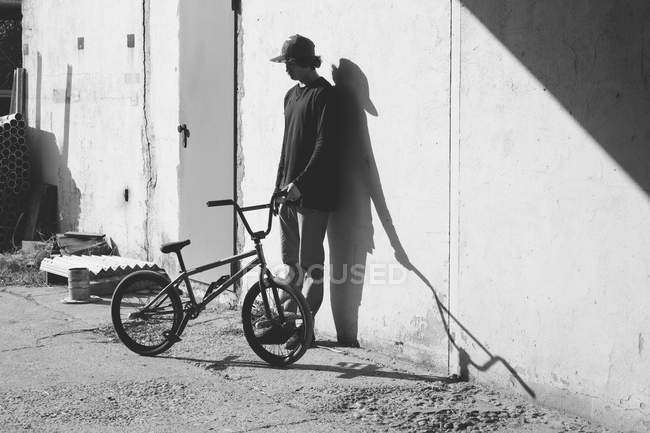 Гонщик BMX стоїть біля стіни — стокове фото