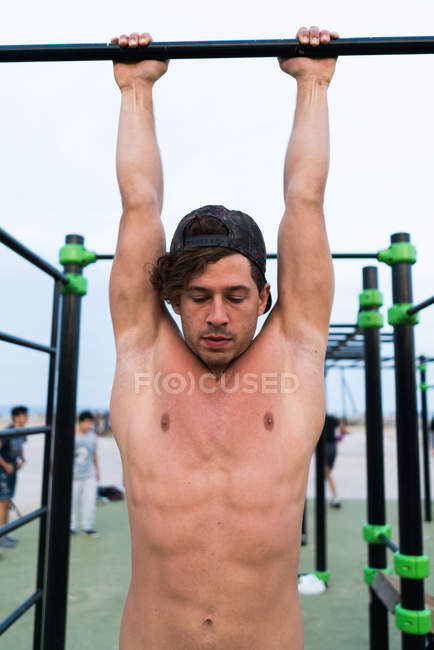Uomo muscolare che si esercita sul mento-up bar — Foto stock