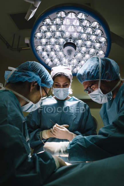 Operación de procesamiento del equipo de cirujanos - foto de stock