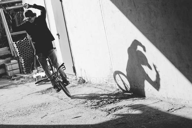 Мотоциклист BMX стоит у стены — стоковое фото