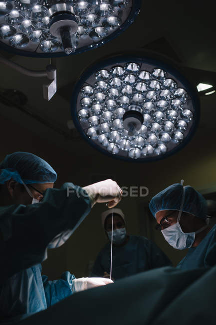 Cirujanos cosiendo después de la operación - foto de stock