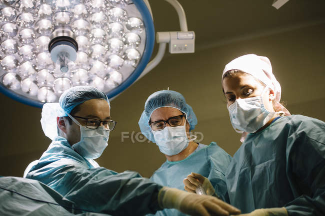 Operación de procesamiento del equipo de cirujanos - foto de stock