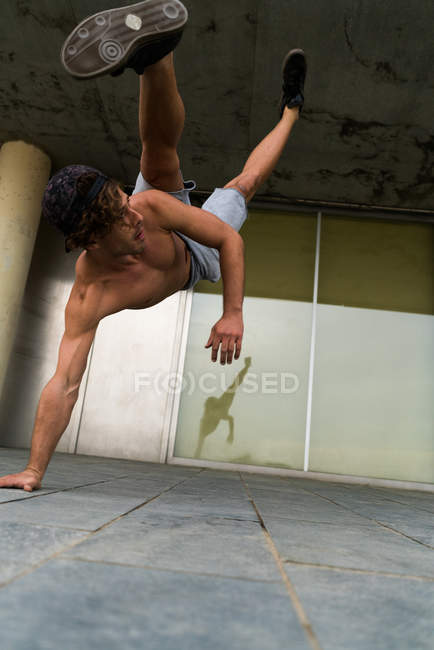 Shirtless man in handstand on street — Stock Photo
