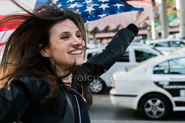Menina bonita com bandeira da América no estacionamento — Fotografia de Stock
