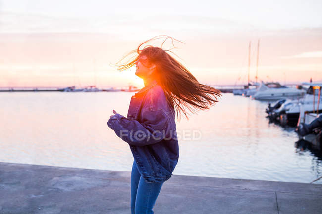 Nette Frau mit wehenden Haaren bei Sonnenuntergang — Stockfoto
