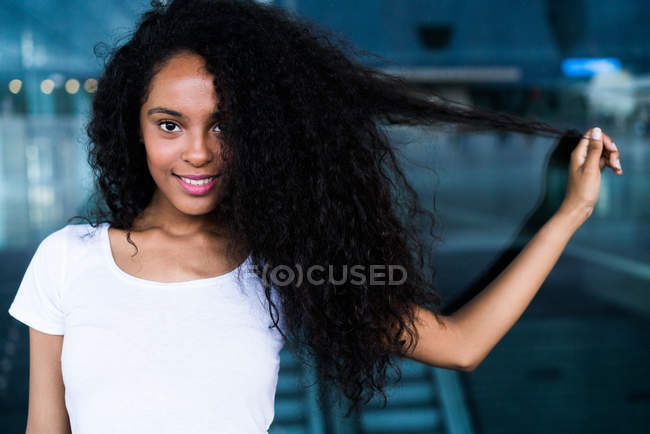 Woman playing with hair in mall — Stock Photo