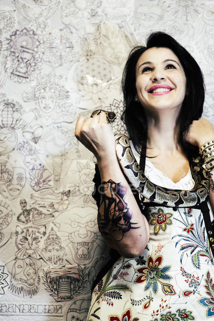 Татуированная женщина улыбается и позирует со змеей . — стоковое фото