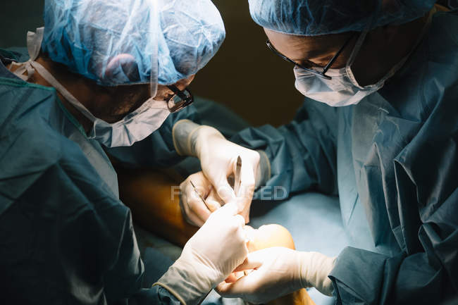 Deux chirurgiens pendant l'opération du patient — Photo de stock