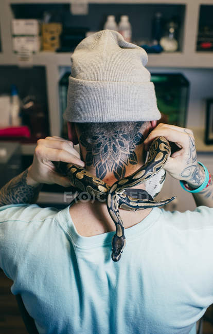 Человек, держащий большую змею, сжимающую шею
. — стоковое фото