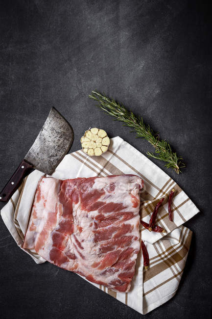Still life of raw pork ribs with herbs and spices on towel — Stock Photo