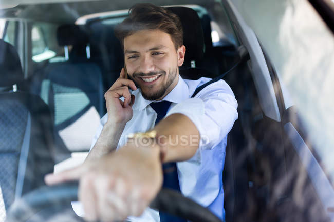 Улыбающийся водитель разговаривает по телефону — стоковое фото