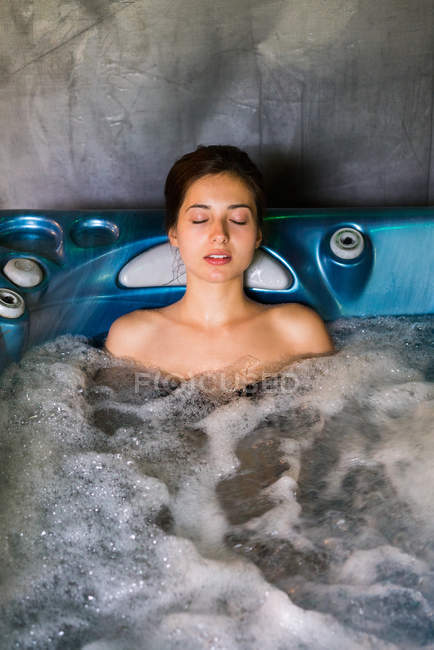 Mujer relajante en jacuzzi - foto de stock