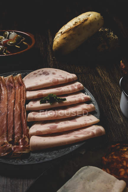 Slices of ham and jamon on plates — Stock Photo