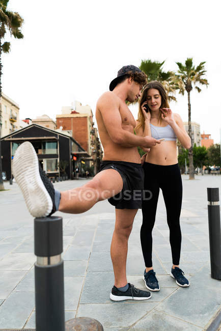 Sportliches Paar mit Telefonen — Stockfoto