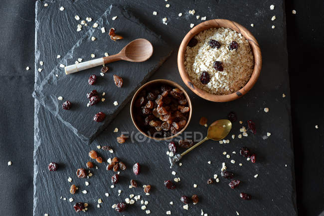 Flocons d'avoine et raisins secs sur table . — Photo de stock
