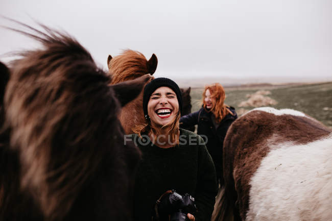 Смеющиеся женщины с лошадьми — стоковое фото