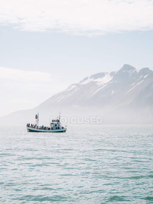 Лодка в море над горой — стоковое фото