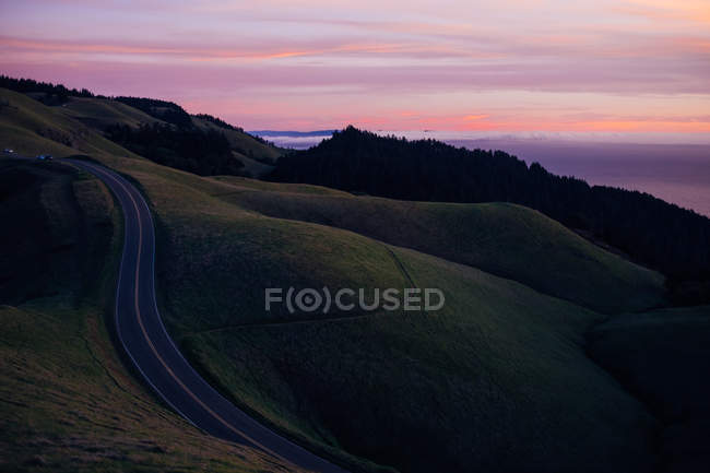 Kurvige Landschaft über violettem Himmel — Stockfoto