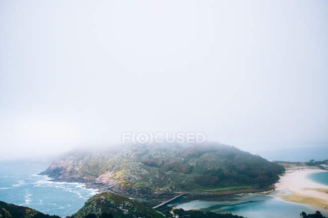 Зеленый остров над туманным небом — стоковое фото