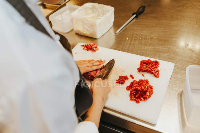 Cozinheiros mãos cortando carne — Fotografia de Stock