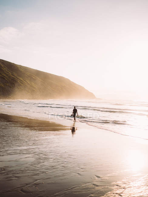 Homem caminhando ao longo da costa . — Fotografia de Stock