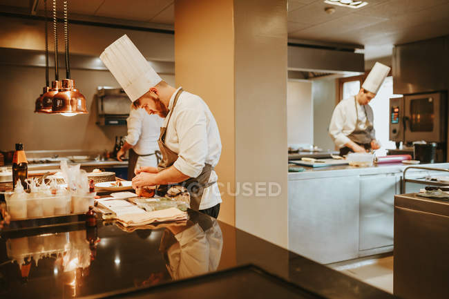 Köche in der Küche, die Gerichte zubereiten. — Stockfoto