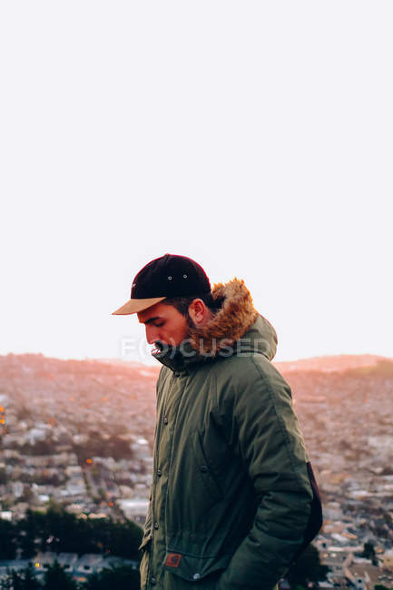 Man in coat over cityscape background — Stock Photo