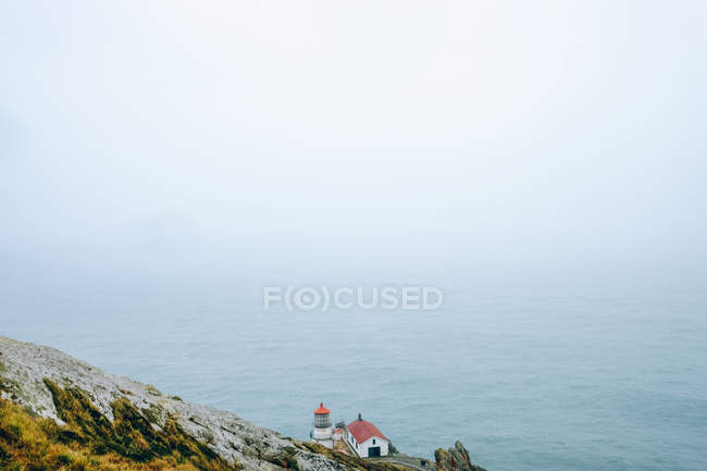 Маяк Пойнт Рейес на скале над морем — стоковое фото