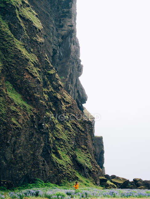 Человек, идущий под скалой — стоковое фото