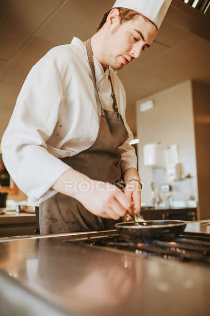 Chef cocinando en sartén - foto de stock