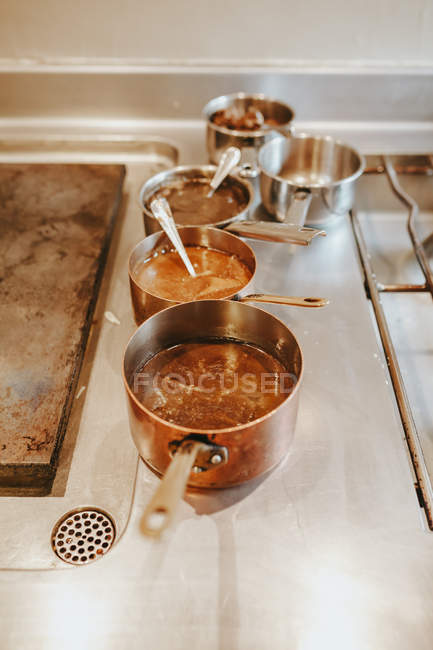 Rangée de différents pots remplis de sauce — Photo de stock