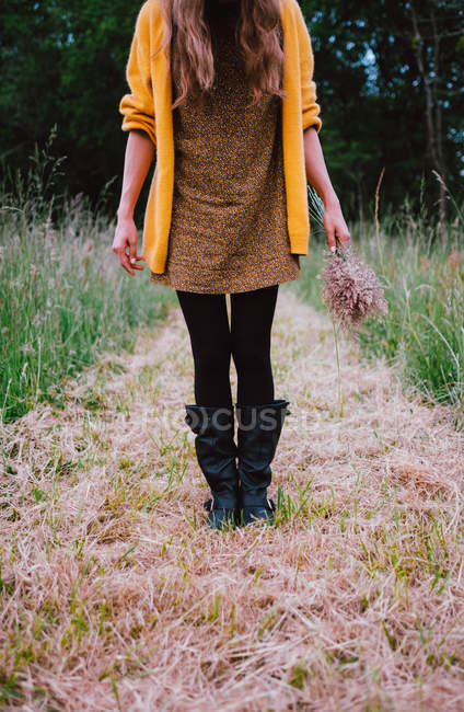 Femme avec un bouquet dans la prairie — Photo de stock